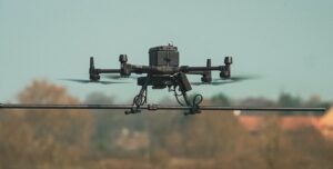 r4 Unmanned Aerial System (UAS) drone in flight against a clear sky - JBUAS