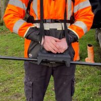 The MagWalk portable magnetometer system is worn by a survey operator in a field environment and designed for ground-based magnetic surveying and geophysical data collection.
